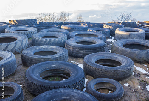 The old rubber tyre from a tractor and a car , laid on the silo . Serve as a load restraint top membrane covering the silage mixture . Dairy farm in Podlasie, Poland.