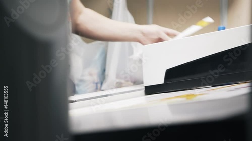 Wallpaper Mural Close up of worker s hands checking colors of an image printed in a printing plant. Left to right pan real time close up shot Torontodigital.ca