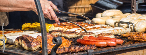 Grillfest: Frau bereitet Bratwürste und Steaks zu photo