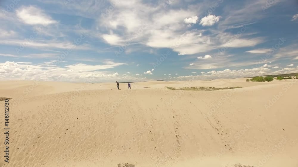 Two men standing on a sand dune 