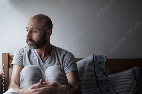 Mid forties depressed man in bed at home