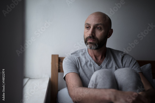 Mid forties depressed man in bed at home