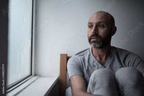 Mid forties depressed man in bed at home