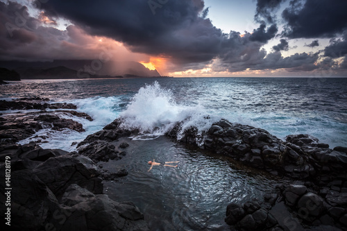 Man swimming in sea during sunset