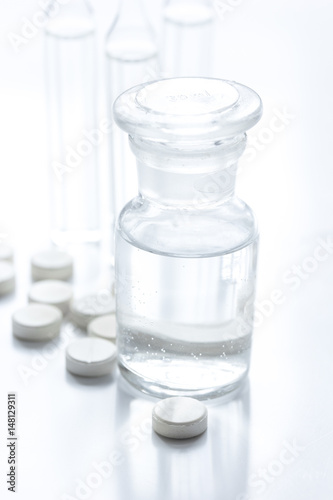 doctor's office table with pills and vials white background