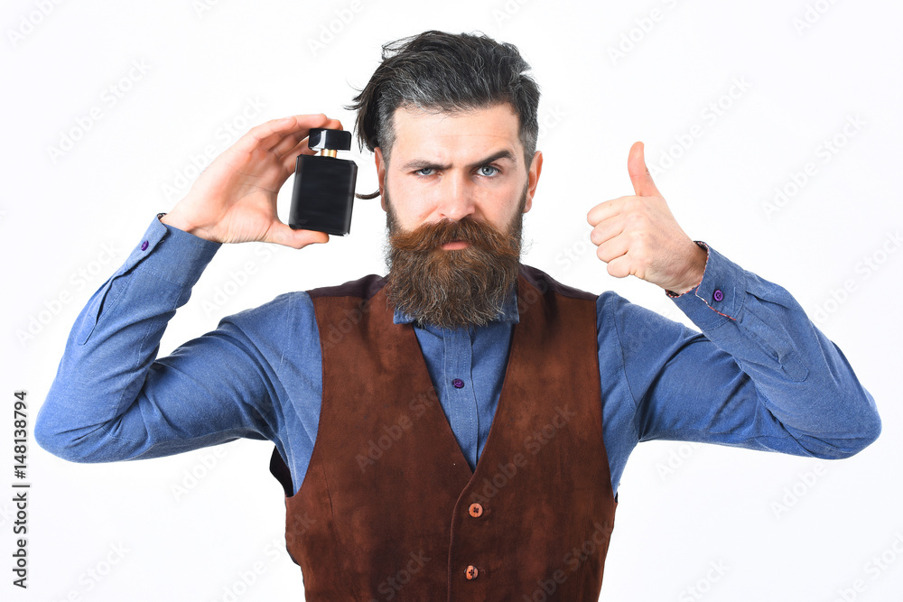 bearded man holding perfume with serious face bearded man holding perfume with serious face