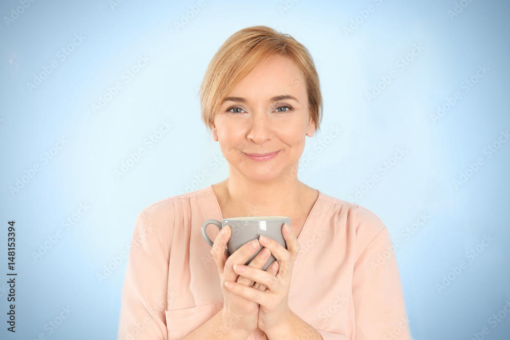 Happy senior woman with cup on light background Happy senior woman with cup on light background