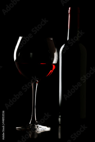 Glass of wine with bottle in darkness