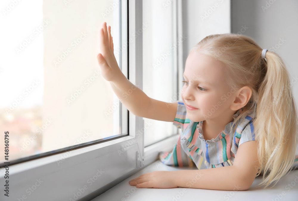Cute little girl lying on windowsill Cute little girl lying on windowsill