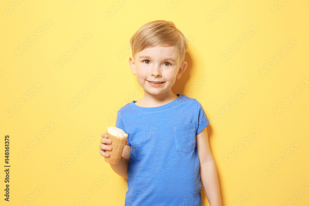 Cute little boy eating ice cream on color background Cute little boy eating ice cream on color background