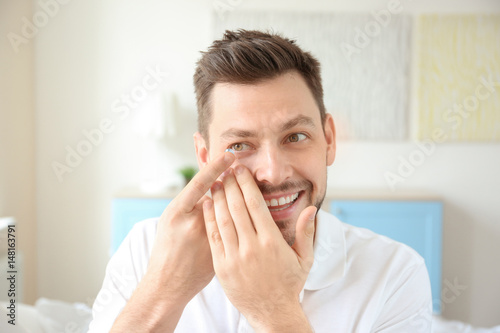 Young man putting contact l...