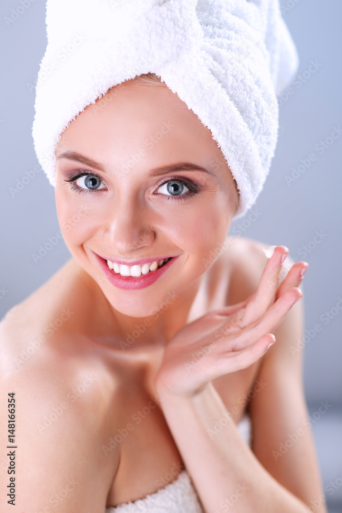 Young woman putting cream on her hand Isolated on gray background Young woman putting cream on her hand Isolated on gray background