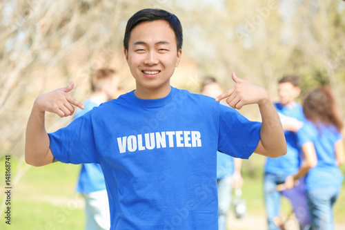Young Asian volunteer with team outdoors