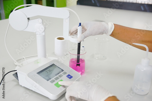 The scientist work at the chemical solution with pH meter