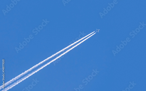Diagonal trace of plane flying in blue sky