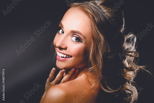 Beautiful woman with curly long hair on dark background