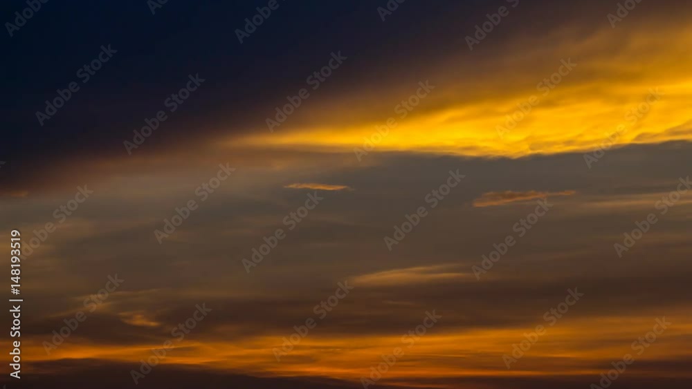 Colorful and dramatic sky unfolds, painting the heavens with vibrant hues. The backdrop showcases orange clouds, creating a breathtaking and mesmerizing scene and dynamic cloud formations, Time Lapse