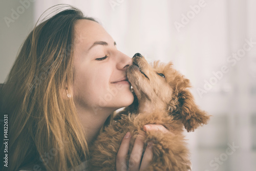 Fotografija Young girl kissing her good friend dog . Positive human emotions.