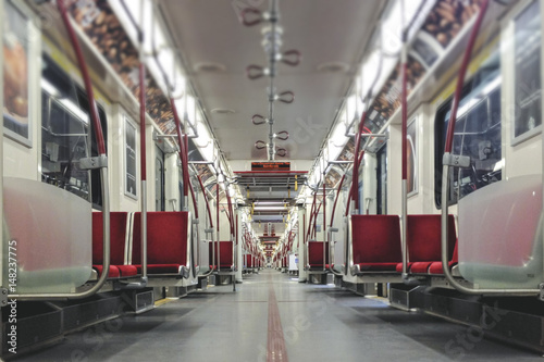 Interior of empty subway car with bright red seats