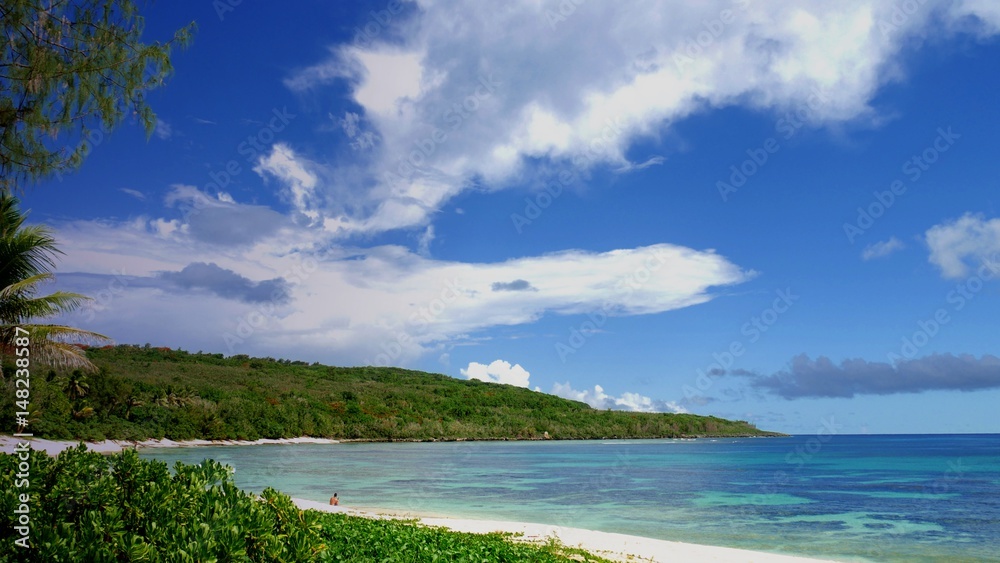 Beautiful blue skies and pristine waters welcome visitors to the Tachogna Beach on Tinian, Northern Mariana Islands.