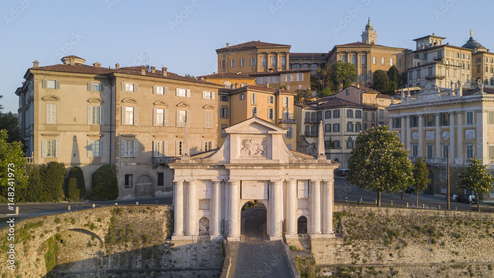 Bergamo - Old city. One of the beautiful city in Italy. Aerial shot of the old gate named Porta San Giacomo during the sunrise and a wonderful blu day