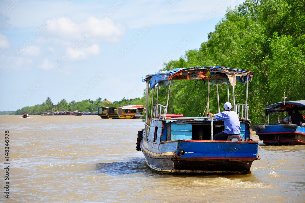 a sailor on a boat without passengers passing through an empty river in Asia. a sailor on a boat without passengers passing through an empty river in Asia.