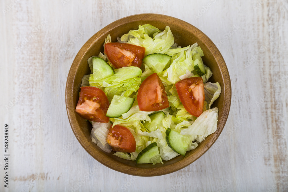 Salad in wooden bowl on a table close-up.