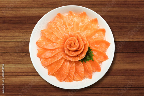 Top view of salmon sashimi serve on flower shape in white ice bowl boat on wood table background, Japanese style.