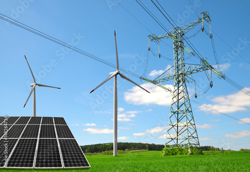 Photo Solar panel with wind turbines and electricity pylon on meadow