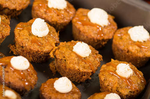 Wallpaper Mural Delicious brown colored muffins lined up with caramel and cream topping, as seen from above angle, pastry concept Torontodigital.ca