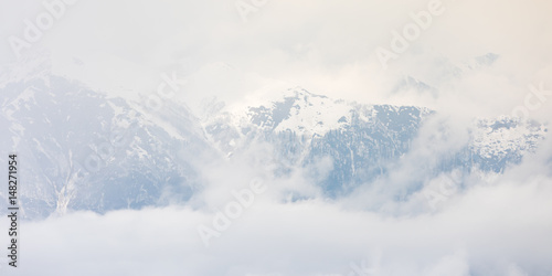 Mountains with snow in the clouds on a sunny day