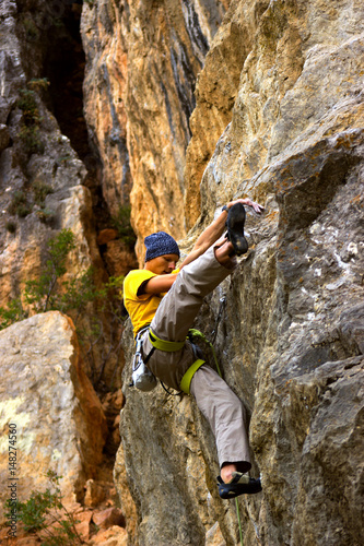 Young male climber hanging on a cliff with a rope.    © trek6500