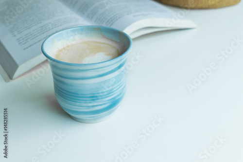 Blue coffee cup on the desk with books. Concept coffee lover background.