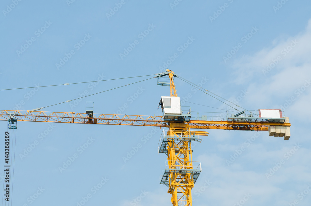 Industrial construction cranes and building on sky background