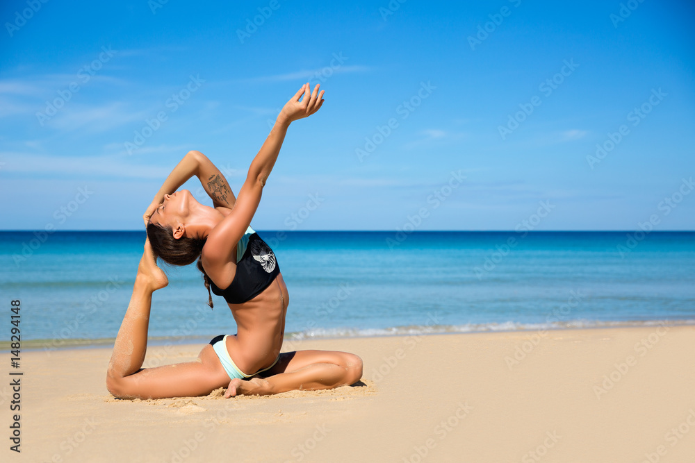Healthy yoga exercise on the beach, slim sporty body training, leisure and meditation, vacation, sport, health care concept, over natural background blue sky and sea. Ashtanga vinyasa Healthy yoga exercise on the beach, slim sporty body training, leisure and meditation, vacation, sport, health care concept, over natural background blue sky and sea. Ashtanga vinyasa
