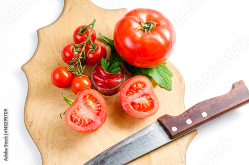 Tomato and knife on the cutting board. Isolated