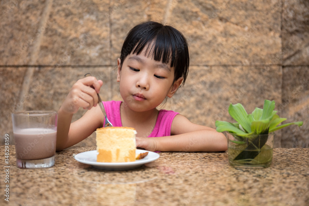 Asian little Chinese girl eating delicious cake Asian little Chinese girl eating delicious cake