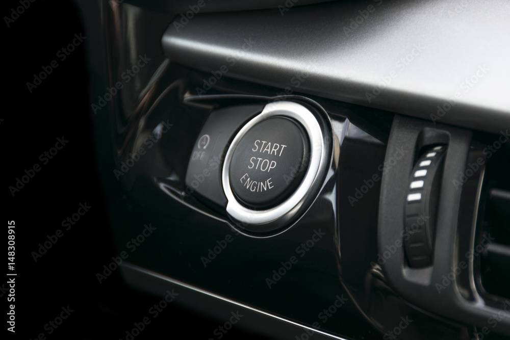 Car dashboard with focus on engine start stop button, car interior details