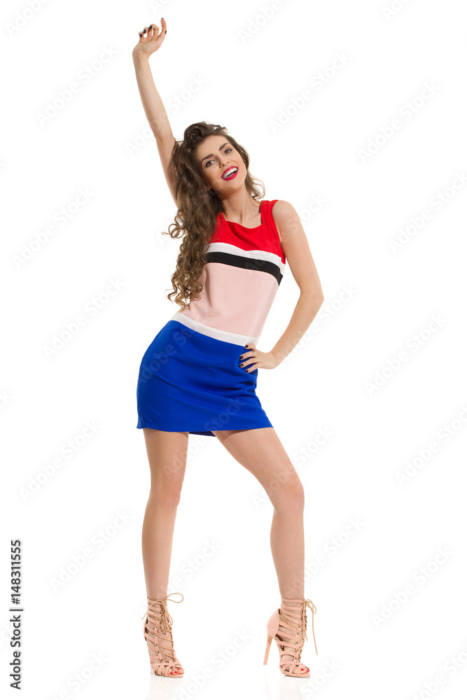 Fashion Model In Mini Dress And High Heels Is Posing With Arm Raised Fashion Model In Mini Dress And High Heels Is Posing With Arm Raised