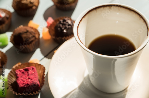 A cup of coffee and chocolate sweets