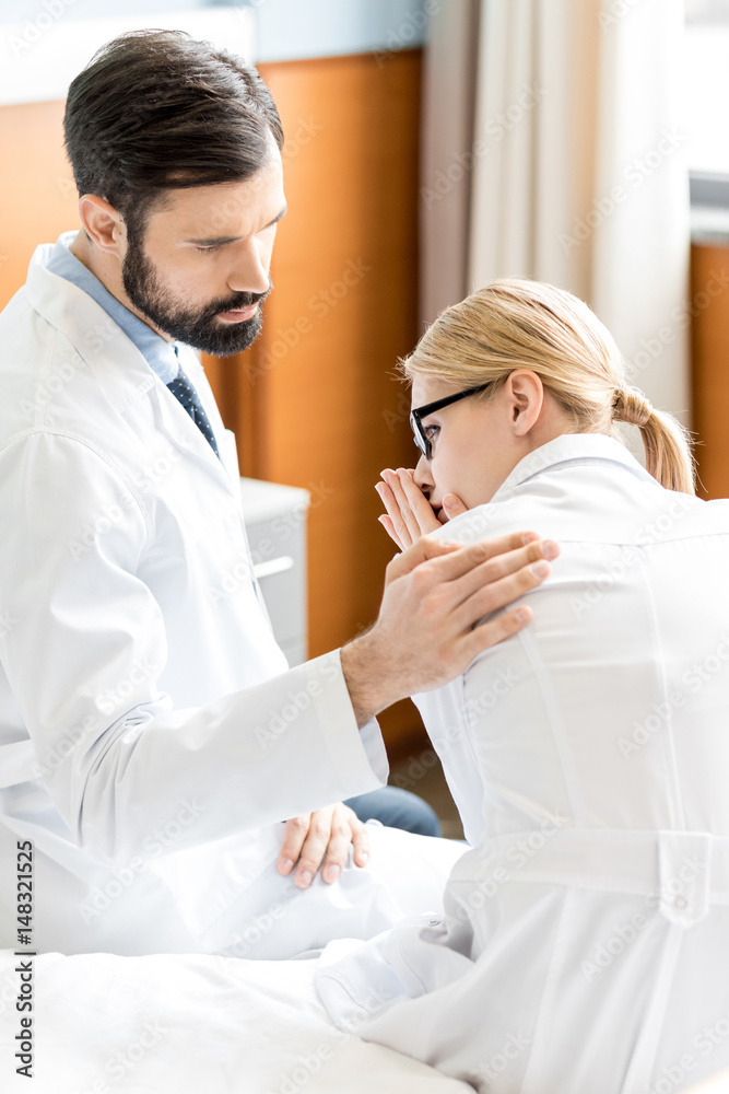 doctor soothing upset colleague doctor soothing upset colleague