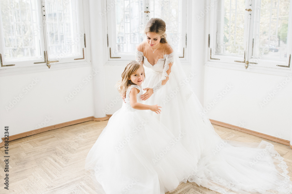 The charming bride with daughter standing in the room The charming bride with daughter standing in the room
