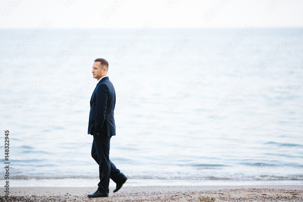 The handsome groom stands near sea The handsome groom stands near sea