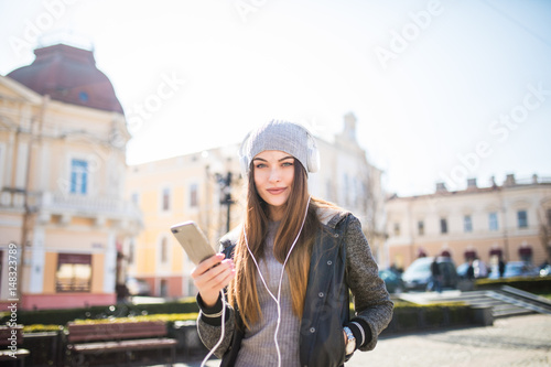 Young happy woman, listening music and having fun on the street Outdoor.