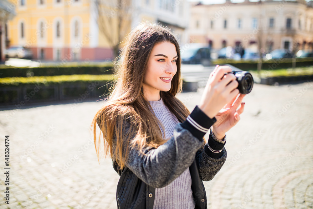 Portrait of a young, fit and attractive woman taking a photo outdoor. Girl looking at the camera.