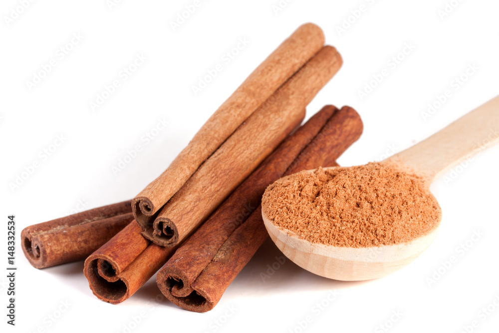four cinnamon sticks and powder with spoon isolated on white background four cinnamon sticks and powder with spoon isolated on white background