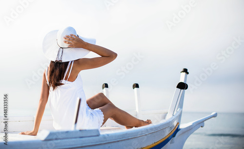 Young girl in hat sitting in boat