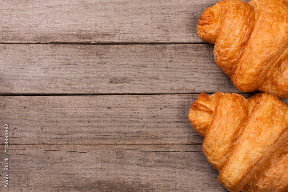 two croissants on old wooden background with copy space for your text. Top view two croissants on old wooden background with copy space for your text. Top view