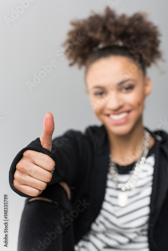 portrait of african american girl showing thumb up isolated on grey