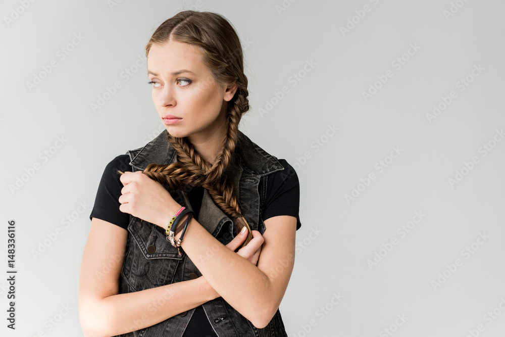 portrait of pensive rocker girl with braids posing and looking away isolated on grey portrait of pensive rocker girl with braids posing and looking away isolated on grey